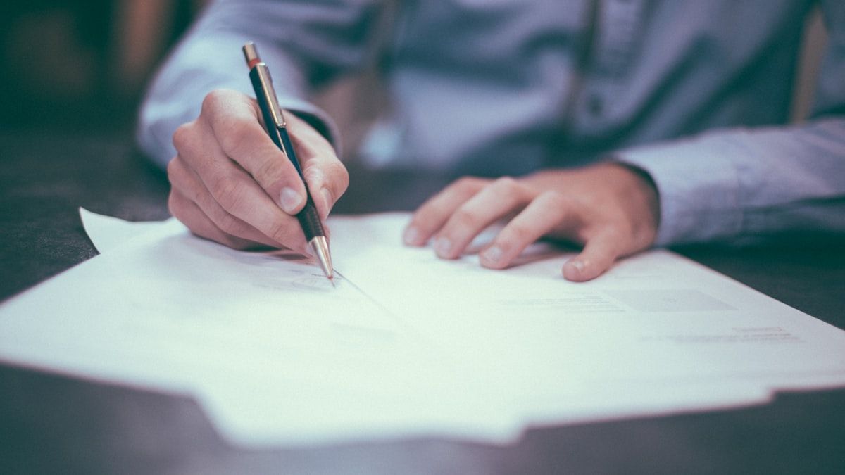 Paciente firmando un consentimiento informado con una pluma